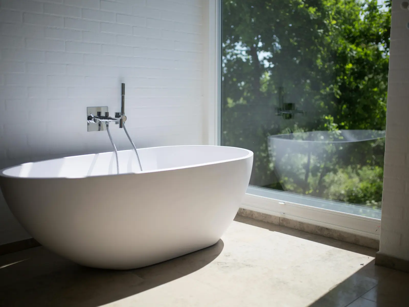 White Ceramic Bathtub Beside Clear Glass Wall White Ceramic Bathtub Beside Clear Glass Wall